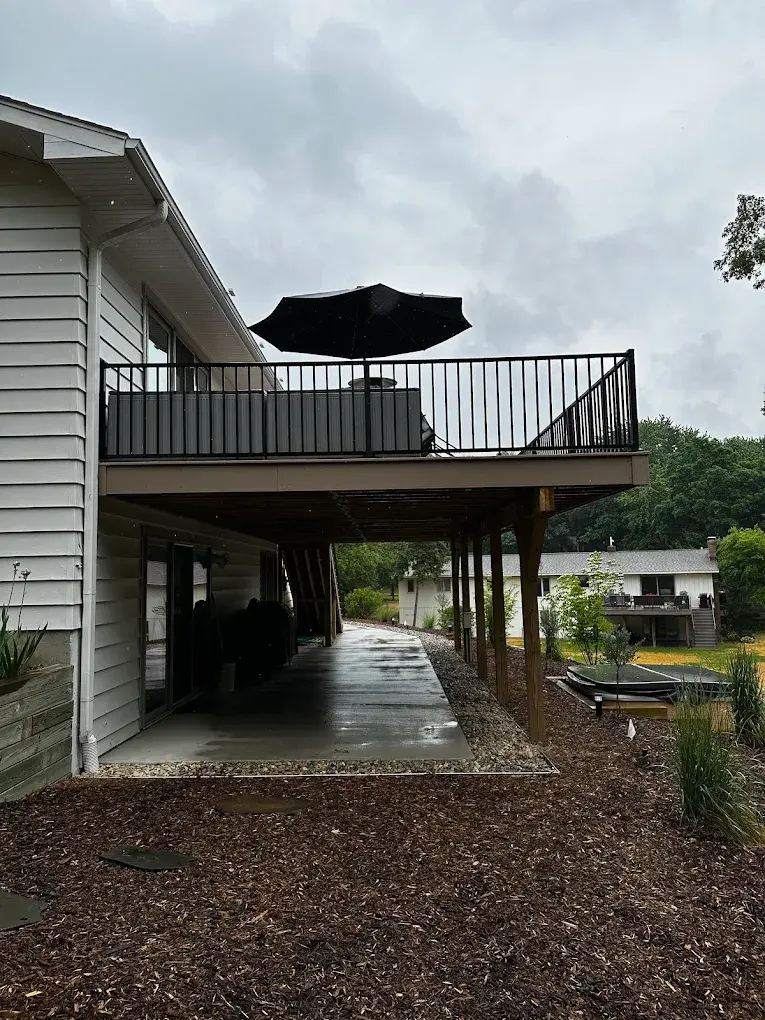 Elevated second-story deck with black metal railing and covered patio area below in Snohomish County