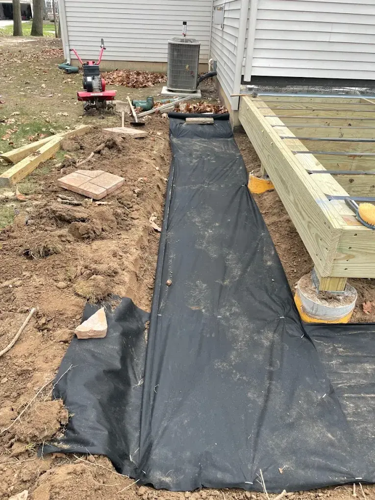 Completed walkway with gravel edging and landscaped mulch beds alongside elevated deck