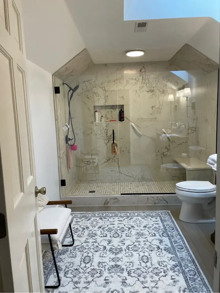 Bright bathroom vanity with black fixtures and stone countertop