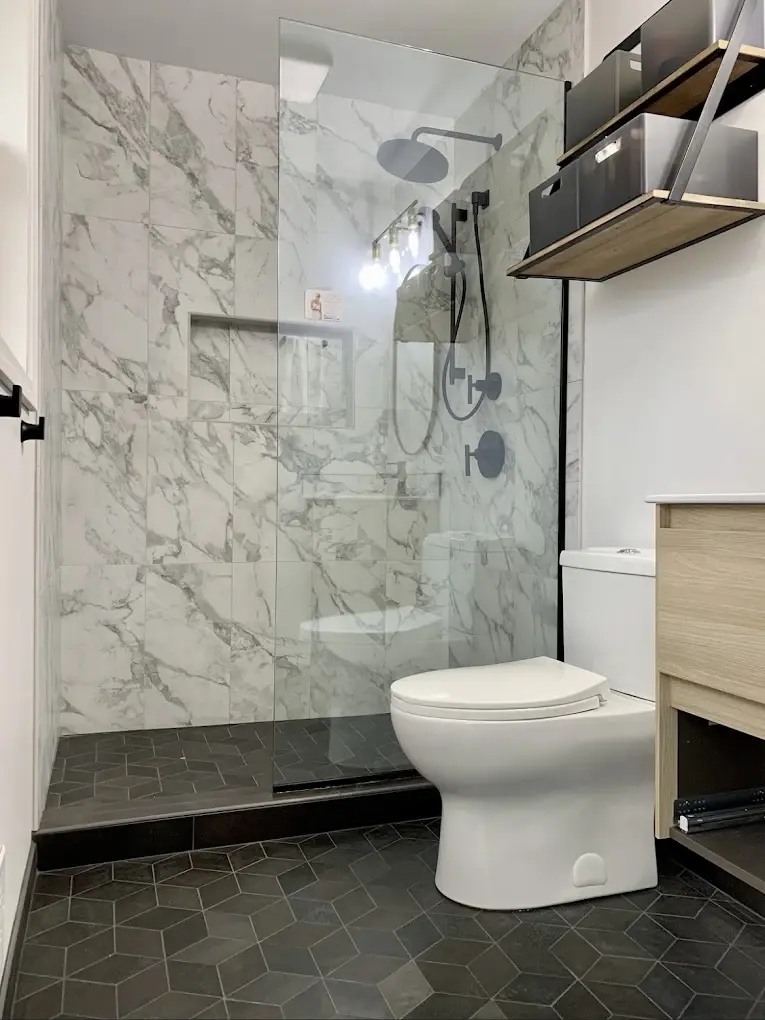 Hands installing porcelain tile during a bathroom remodel in Mukilteo