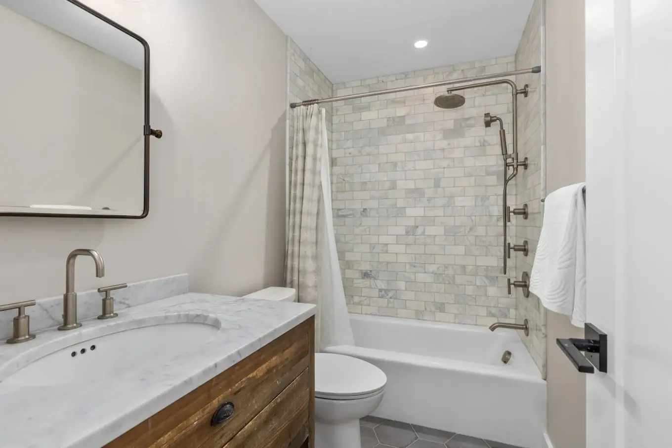 Finished bathroom with patterned accent tile and custom tile surround
