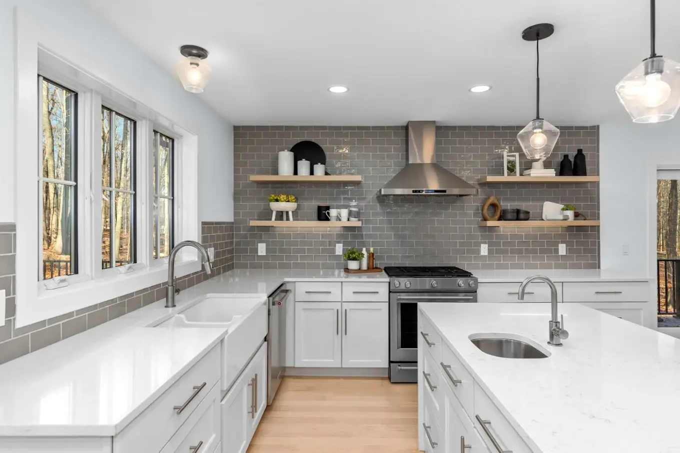 Completed kitchen remodel with white shaker cabinetry, quartz island, gray subway tile backsplash, and floating wood shelves in Mukilteo WA