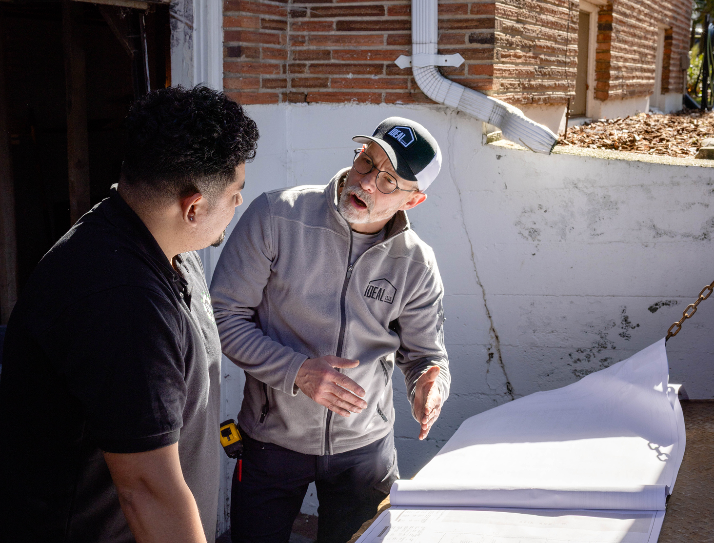 Two team members reviewing construction plans outside the project site