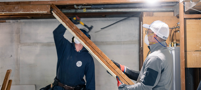 Crew members lifting a beam during framing work
