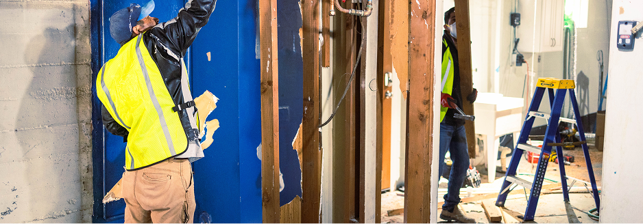 Crew members working inside a framed room
