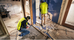Worker marking measurements on a framed wall