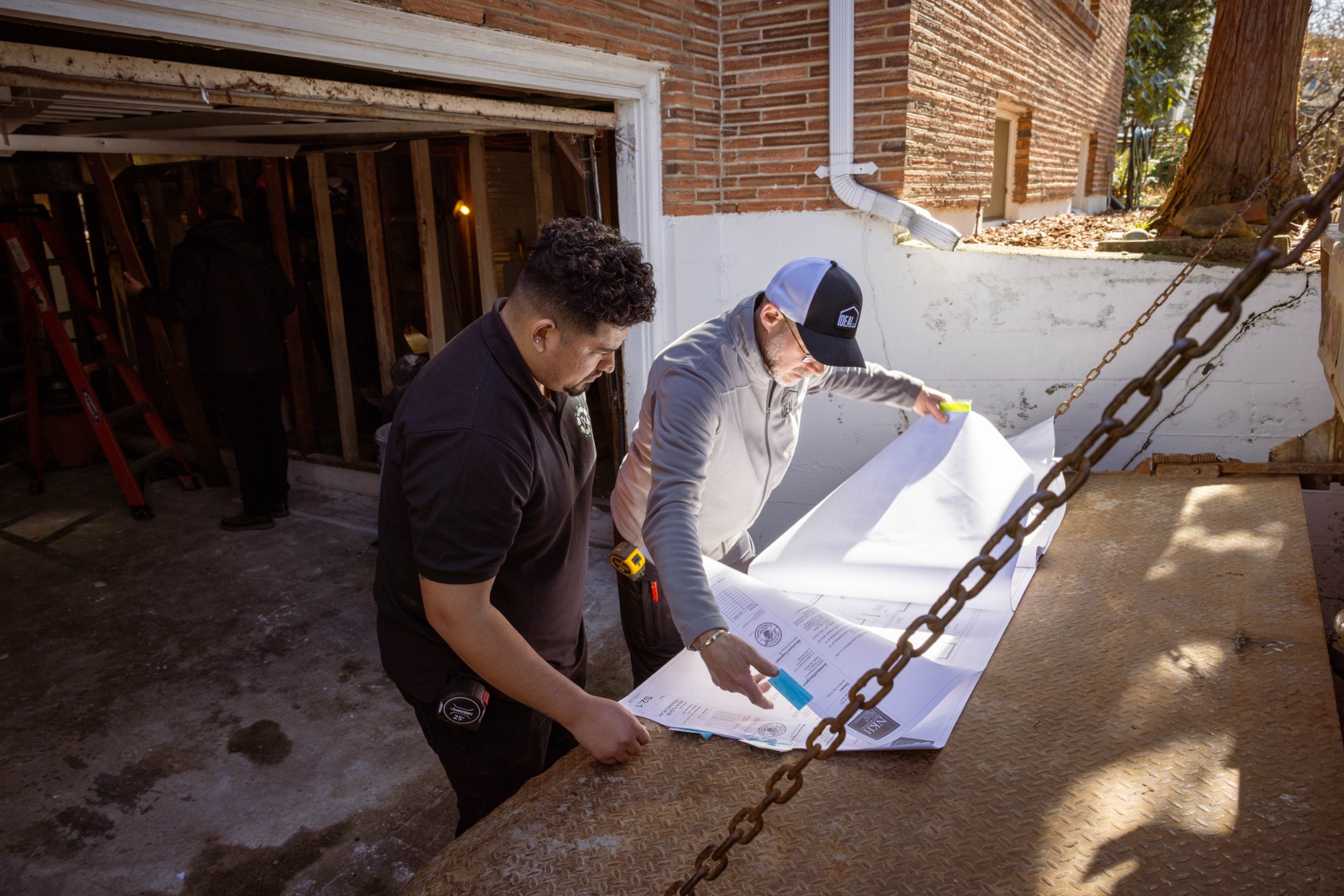 Christian and an Ideal team member reviewing plans on site